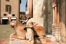 Kathedraal,Torre Civica en Piazza Grande, Modena - De kathedraal van Modena: De Porta Regia met beeldhouwwerk van de Campionese Meesters. De gebeeldhouwde leeuwen zijn gemaakt van roze marmer, ze...