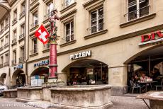 Oude stad van Bern - Oude stad van Bern: De Ryfflibrunnen en erachter de overdekte arcades in de Aarbergergasse. De Ryfflibrunnen is vernoemd naar Ryffli, een...