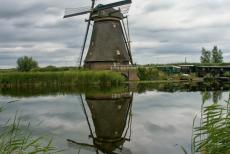 Molengang van Kinderdijk-Elshout - Een van de molens van Kinderdijk weerspiegeld in het water. Vanaf een voet- en fietspad langs de ringvaart zijn de windmolens...