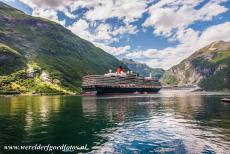 Geirangerfjord and Nærøyfjord - West Norwegian Fjords: The huge Queen Elizabeth cruise ship in the Geirangerfjord. The fjord is surrounded by some of the steepest mountains...