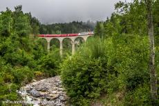 Rhätische Bahn in het Albula / Bernina landschap - Rhätische Bahn in het Albula / Bernina landschap: De rode Glacier Express passeert het 36 meter hoge Schmittentobelviaduct....