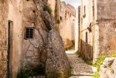 Sassi di Matera en grotkerken van Matera - De Sassi di Matera en de grotkerken van Matera: Een smal straatje in de Sassi di Matera, achter de geveltjes liggen eenvoudige...