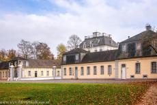 Falkenlust Castle in Br&uuml;hl - Castles of Augustusburg and Falkenlust at Br&uuml;hl: The&nbsp;outbuildings at the&nbsp;back&nbsp;of Falkenlust Castle. The forested areas around...