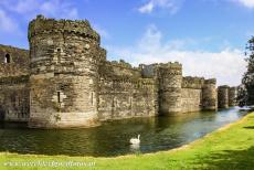 Beaumaris Castle - Castles and Town Walls of King Edward in Gwynedd: The outer wall and the moat of Beaumaris Castle. Four lines of massive fortifications...