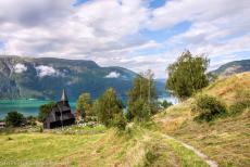 Urnes Stave Church - The Urnes Stave Church, in the background the Lustrafjord. The wooden church is surrounded by the breathtaking nature of Norway The...