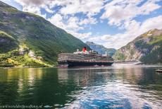 Geirangerfjord and Nærøyfjord - West Norwegian Fjords: The huge Queen Elizabeth cruise ship in the Geirangerfjord. The fjord is surrounded by some of the steepest mountains...