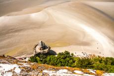 Mont Saint-Michel en zijn baai - Mont Saint-Michel en haar baai: Laag tij gezien vanuit de kloostertuinen van de Abdij van Mont Saint-Michel. De abdij staat op een...