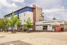 Modernistische woonwijken in Berlijn - Modernistische woonwijken in Berlijn: Enkele winkels en een restaurant in de Hufeisensiedlung. In een winkel is nu een...