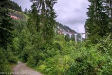Rhaetian Railway, the Albula and Bernina Lines - Rhaetian Railway in the Albula / Bernina Landscapes: A train passes over the single-track Landwasser Viaduct. The 65-metre-high and 142-metre-long...