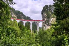 Rhaetian Railway, the Albula and Bernina Lines - Rhaetian Railway in the Albula / Bernina Landscapes: A train on the iconic Landwasser Viaduct outside the Alpine village of Filisur. It seems as...
