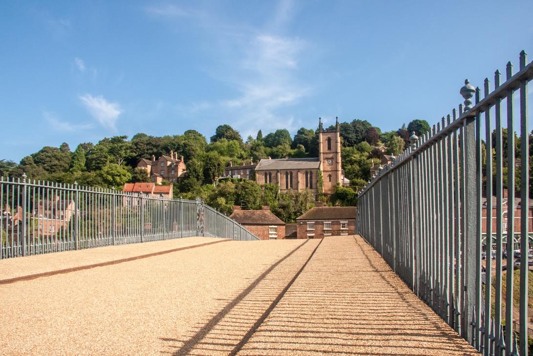 Ironbridge Gorge - The Iron Bridge, in the background the St. Luke's Church in the small village of Ironbridge. The Iron Bridge is the most famous monument of...