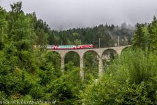 Rhätische Bahn in het Albula / Bernina landschap - Rhätische Bahn in het Albula / Bernina landschap: De beroemde Glacier Express passeert het Schmittentobelviaduct bij het dorp...