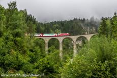 Rhätische Bahn in het Albula / Bernina landschap - Rhätische Bahn in het Albula / Bernina landschap: De beroemde Glacier Express passeert het Schmittentobelviaduct bij het dorp...