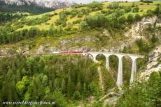 Rhaetian Railway, the Albula and Bernina Lines - Rhaetian Railway in the Albula / Bernina Landscapes: A red train on the Landwasser Viaduct. In addition to the passenger and goods trains,...