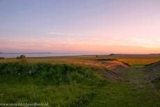 Ringforten uit de Vikingtijd - Een deel van de aarden wallen en de gracht van het ringfort Aggersborg, met de Limfjord op de achtergrond. Deze langgerekte binnenzee is... Ringforten uit de Vikingtijd - Een deel van de aarden wallen en de gracht van het ringfort Aggersborg, met de Limfjord op de achtergrond. Deze langgerekte binnenzee is...